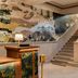 The Flat Iron Hotel in Asheville lobby with mural wall, staircase, and seating area