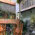 @K Hotel Kaliurang Yogyakarta garden play area with bamboo chairs and a stone wall in Yogyakarta