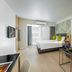Citadines Sukhumvit 16 Bangkok room with bed, sofa, desk and balcony view in Bangkok