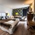 Meltar Boutique Hotel in Asiago bedroom with king bed, patterned accent wall, and seating area