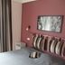 Hôtel De La Paix, Gérardmer: double bed with gray cover, striped pillows, and mauve accent wall