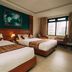 Hotel Tulsi Pokhara guest room with two beds, wood-paneled wall and large window