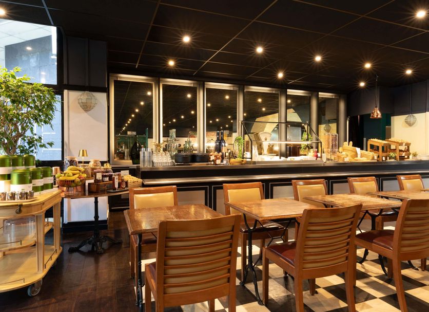 ibis Paris Tour Eiffel Cambronne 15ème dining area with wooden tables, chairs and buffet counter in Paris