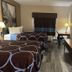 Hotel Piney Woods Huntsville guest room with two beds, TV, desk, and window drapes