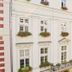 Unikat Guest Rooms in Krakow, exterior of a white building with flower boxes on windows