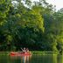 Puerto Valle Hotel De Esteros in Puerto Valle with guests paddling a red kayak on a lush jungle river