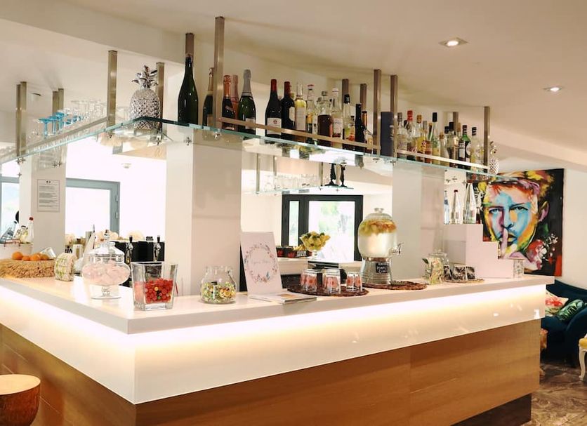 Apparthotel La Girafe bar counter with bottles and stools in La Penne-sur-Huveaune