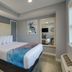 Ocean Lodge Hotel North guest room with king bed, wall mirror, and window view in Ocean City