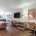 Motel 6 Newport News, VA room with two beds, desk, wall-mounted TV and wood-look flooring