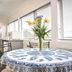Trafalgar Lodge, Nelson: bright dining area with floral centerpiece, round table and large windows