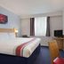 Ramada by Wyndham Wakefield room in Ossett with king bed, desk, TV and window with curtains
