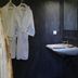 Hôtel confidentiel Le Grecale bathroom with two robes, sink, mirror and dark walls in Pianottoli-Caldarello