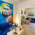 Hotel La Playa Blanca in Santo Stefano di Camastra lounge with blue sofa, colorful mural, and potted plants