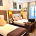 Hôtel Clairefontaine Paris twin bedroom with two beds, desk, and window with curtains