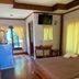 Sri Phairin Resort in Chanthaburi guest room with bed, TV, wooden floor and balcony doors