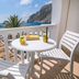 Hotel Sunshine in Kamari balcony with table, chairs and sea view toward rocky cliffs