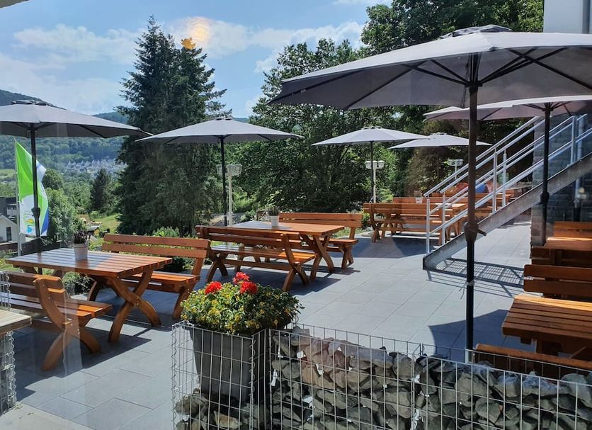 Pension Haus Diefenbach in Heimbach with outdoor terrace seating, umbrellas, and hillside views