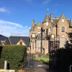 Rosebank Guest House in Perth, stone guest house behind ornate gate and hedges under blue sky