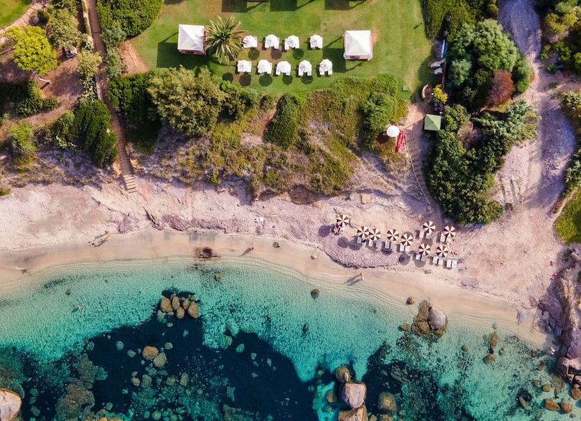 Hotel Cala Caterina in Villasimius with private beach, turquoise bay, and seaside lounge chairs