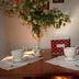B&B Gildo Trani breakfast table with teacups, flowers, and a red polka-dot gift box in Trani