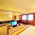 Dalian Jinbai International Hotel room with bed, TV, sofa and large window in Dalian