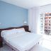 Hotel Plaça in Sant Feliu de Guíxols: bright guest room with bed, chair and balcony door to city view