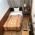 Business Hotel Crescent Tokyo single room with bed, nightstand, lamp and TV