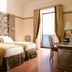 Grand Hotel Europa Palace in Sorrento: twin beds, ornate headboard, desk, and balcony door in guest room