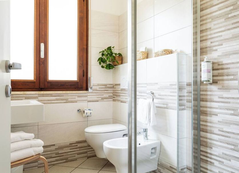 La Tavernetta Ravenna bathroom with glass shower, bidet, toilet, tiled walls and window