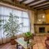 Hotel Villa de Cabrales in Las Arenas lounge with fireplace, large window, potted plant and red armchair