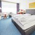 Waldhotel Bärenstein in Horn-Bad Meinberg guest room with king bed, seating area, and large window