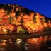 Hotel Matsukaze in Toyota beside a river, with illuminated autumn trees reflecting in the water