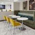 Hampton Inn Kansas City The Legends lobby seating area with yellow chairs and round tables
