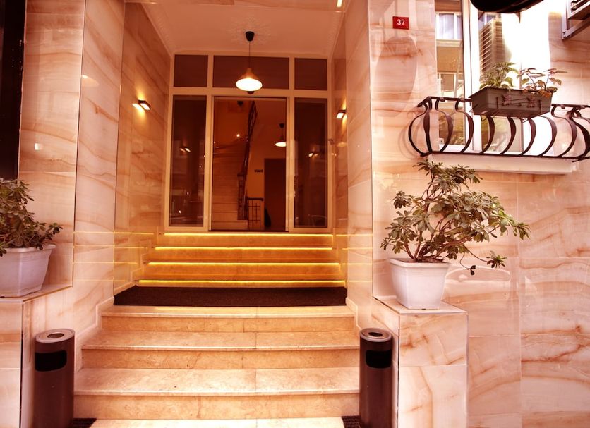 Sisli Mls Hotel in Istanbul entrance with lit steps, glass doors, potted plants and marble facade