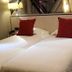 La Confiance in Le Mont-Saint-Michel: twin beds with white linens and red accent pillows