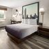 Super 8 by Wyndham Latham/Albany Airport guest room with bed, TV, window and cityscape wall art in Latham