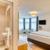 Hotel Leipziger Hof in Innsbruck: guest room with bathroom, bed, seating area and wall-mounted TV