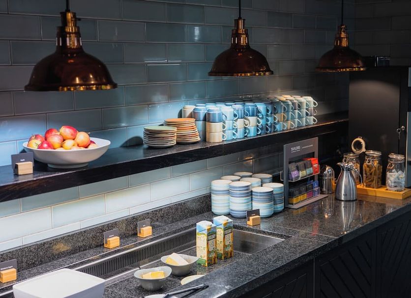 a&o London Docklands Riverside buffet counter with bowls, cups, plates and coffee machine in London