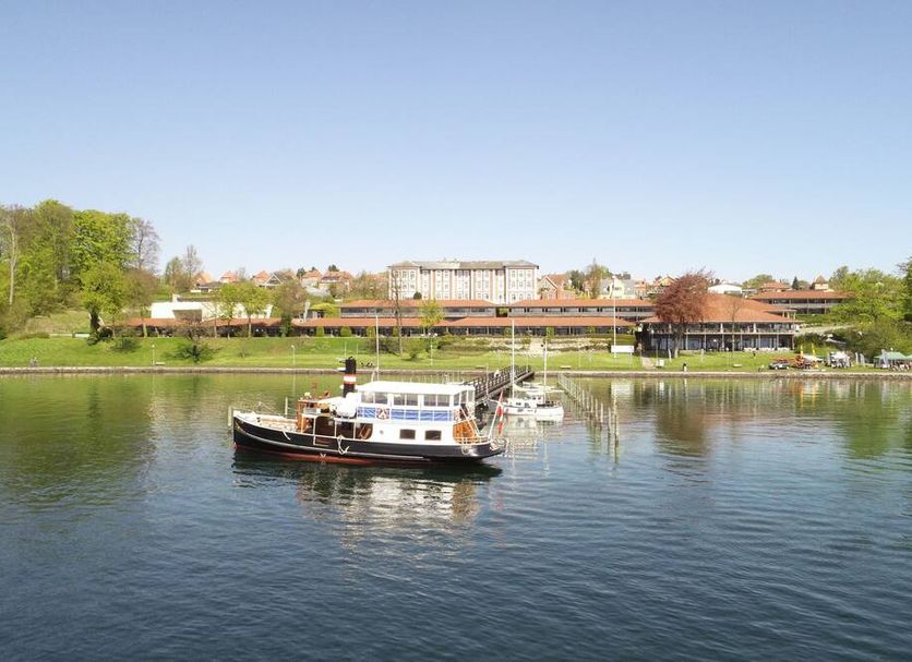 Christiansminde in Svendborg with a boat on calm water and lakeside hotel buildings in the distance