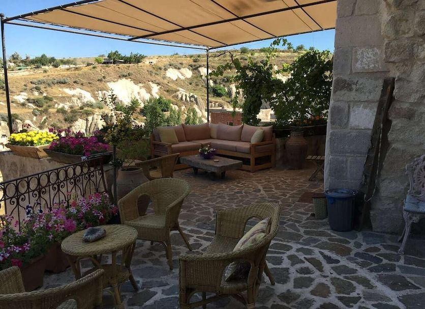 Anitya Cave House in Ürgüp terrace with seating, flowers, canopy and hillside view