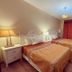 Motel Casa Penn in Newark twin bedroom with bedside lamps, TV, and red curtains