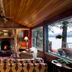 Lake Placid Lodge lounge with fireplace, wood-paneled ceiling, and lake views through large windows