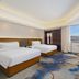 Dushanzi Hotel room in Ürümqi with two twin beds, desk, city view, and TV