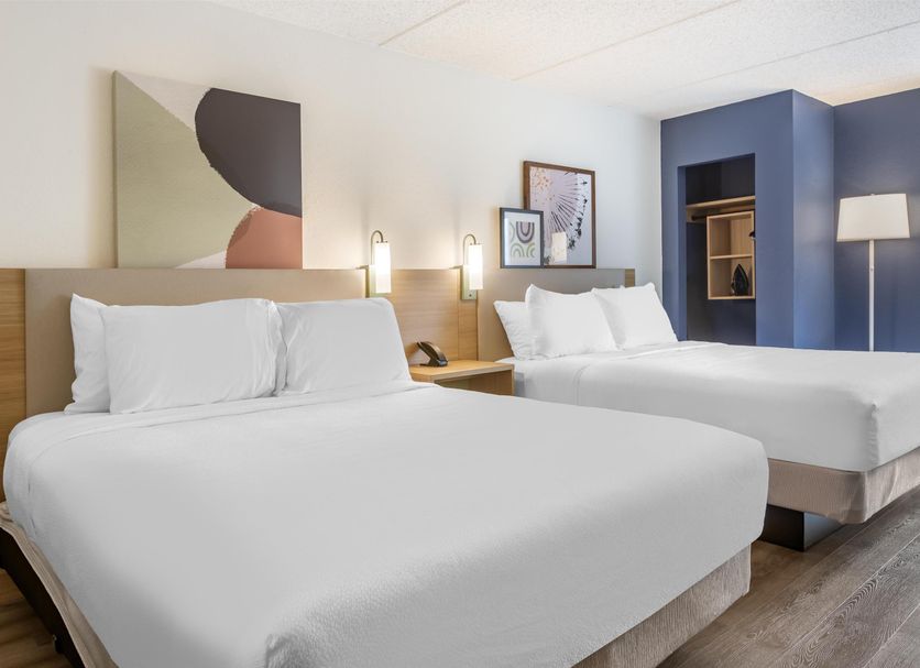 Spark by Hilton Atlanta Airport South College Park guest room with two beds, blue accent wall, and floor lamp