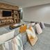 City Express Plus by Marriott Tijuana lounge with brick shelving, TV, and gray sectional sofa