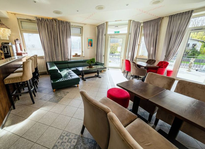Hotel Maj Inn in Moravske Toplice lounge with seating, bar, and large windows