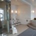 Central Hotel Fukuoka spa area with tiled bath, glass shower and curved soaking tub in Fukuoka