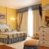 Hotel Playa Compostela guest room in Vilagarcía de Arousa with ornate bed, dresser and balcony curtains