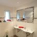 First Mountain Montafon in Gaschurn bathroom with twin sinks, large mirror, and frosted windows