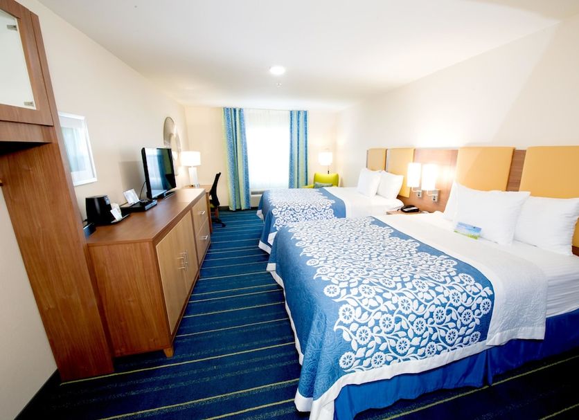 Arya Inn & Suites Farmers Branch guest room with two beds and blue striped carpet in Farmers Branch